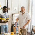 Dwóch wolontariuszy pakuje torby z darami w pomieszczeniu