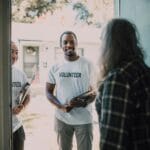 Dwójka wolontariuszy z dokumentami odwiedza podopiecznego w domu