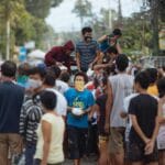 Grupa różnorodnych osób na zewnątrz podczas sąsiedzkiej akcji charytatywnej