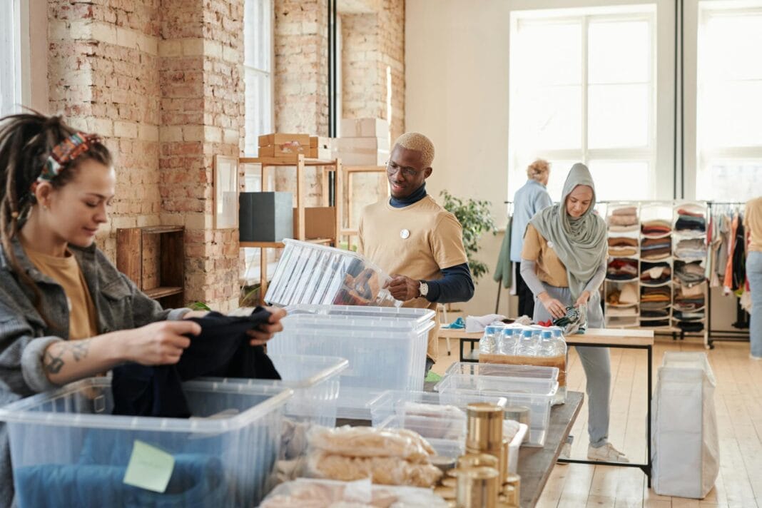 Wolontariusze segregują darowizny odzieży i artykułów w magazynie