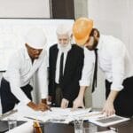 Zespół analizuje plany budynku w biurze podczas pracy nad projektem