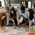 Zespół młodych osób planuje projekt przy biurku z wykresami