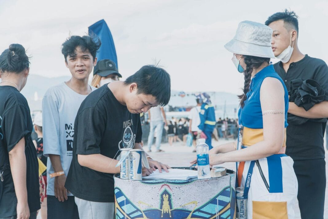 Młodzi wolontariusze zapisują się przy stoisku na wydarzeniu plenerowym