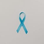 Niebieska wstążka symbolizująca świadomość raka na białym tle
