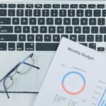 Biurko z laptopem, raportem budżetowym i okularami w nowoczesnym biurze