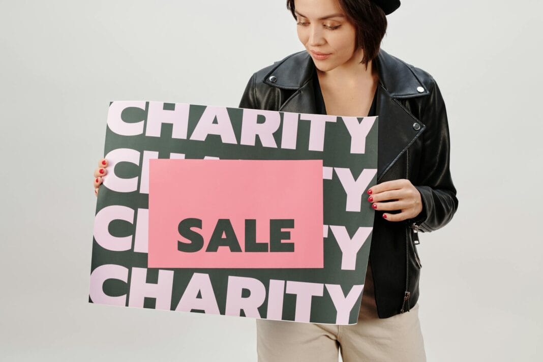 Kobieta trzymająca tabliczkę charity sale na zbiórce w studio