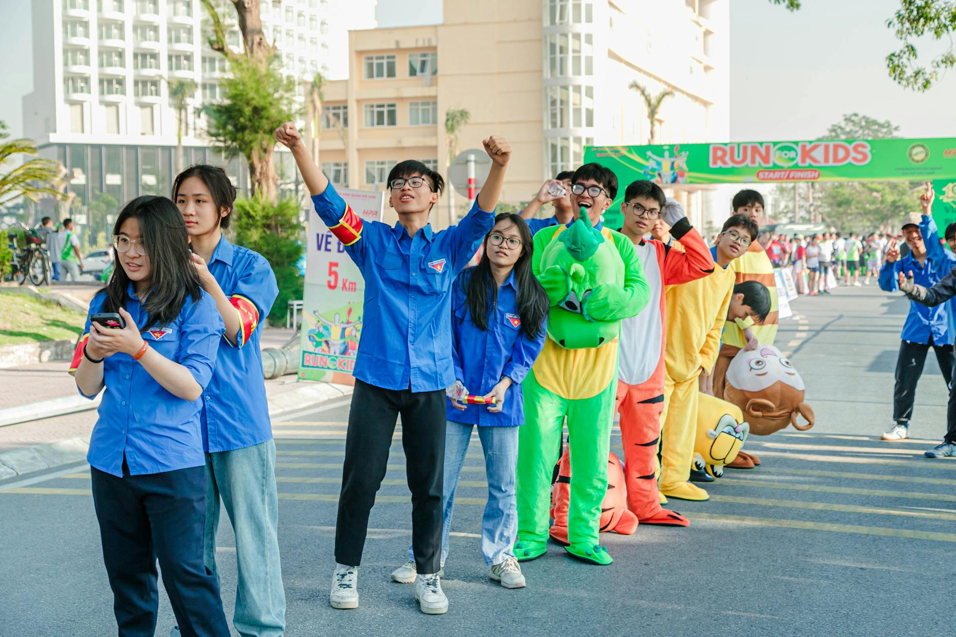 Nastolatki w kolorowych strojach biegną w charytatywnym biegu plenerowym