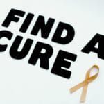 Złota wstążka z napisem Find a Cure na białym tle