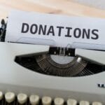 Stara maszyna do pisania z kartką z napisem DONATIONS