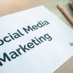 Strategia komunikacji NGO: jak spiąć social media, stronę i newsletter w jeden plan Dokument strategii social media na biurku z długopisem i notesem