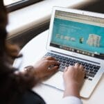 Kobieta pracuje przy laptopie z otwartą stroną zbiórki fundraisingowej